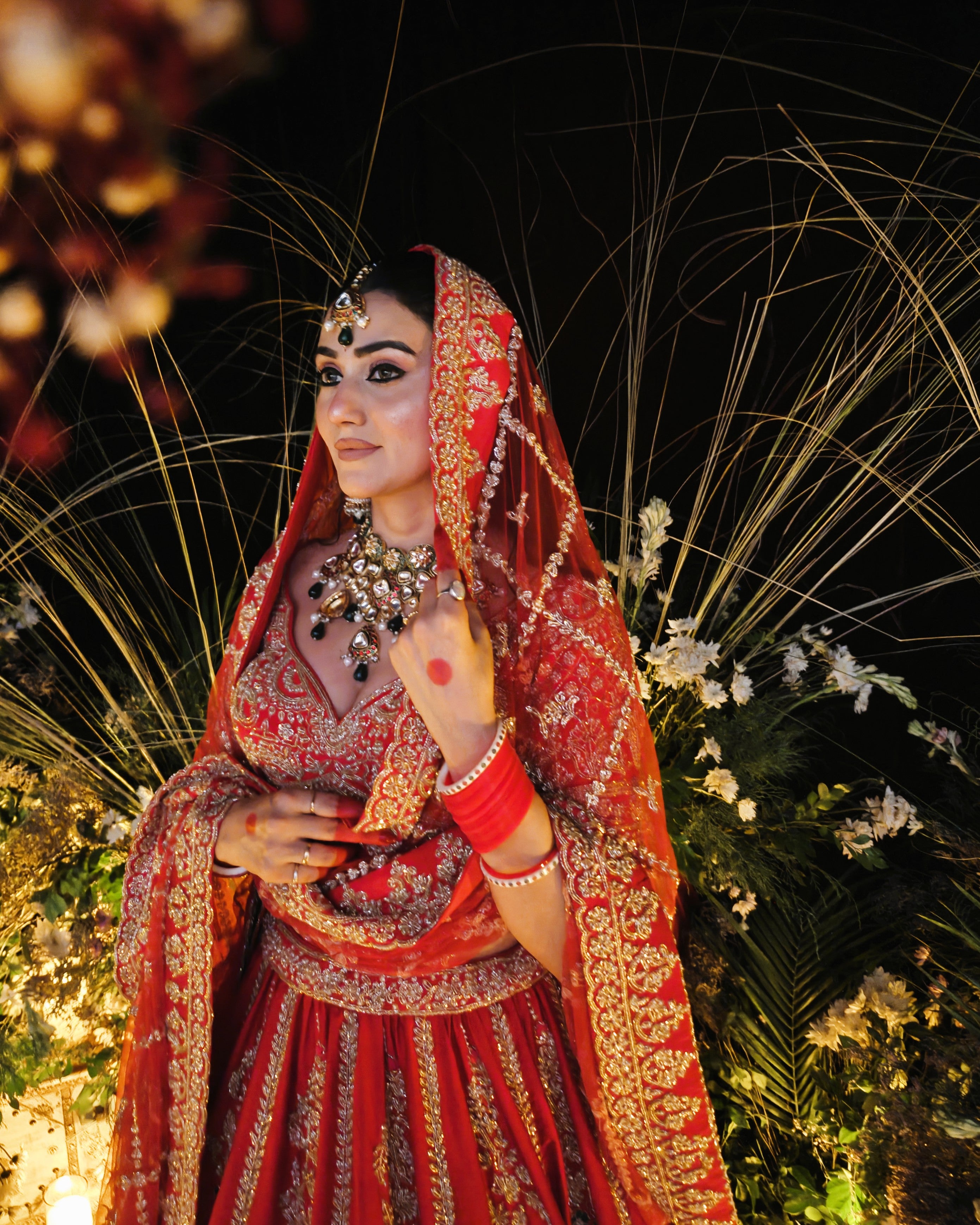 Anahita red bridal lehenga with green hangings on the blouse, Amaltas Couture