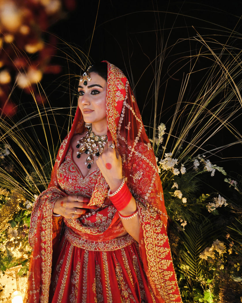 Anahita red bridal lehenga with green hangings on the blouse, Amaltas Couture