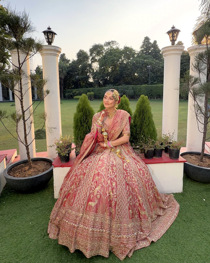 Gulrang pink tissue bridal lehenga seated in a garden, massive flare spread out, Amaltas Couture